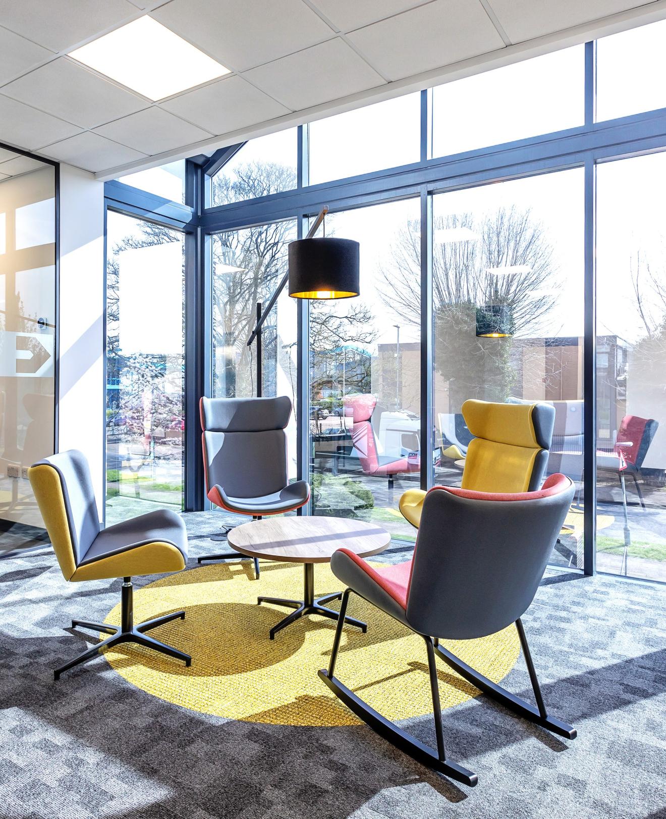 An office breakout area in an Oxfordshire office with four armchairs around a table and a light above them.