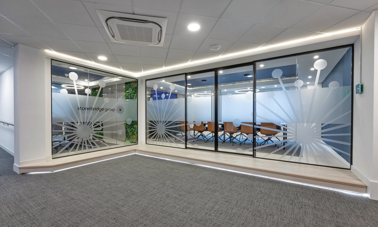 hallway with ambient lighting leading to glass double doors to a meeting room with wooden swivel chairs