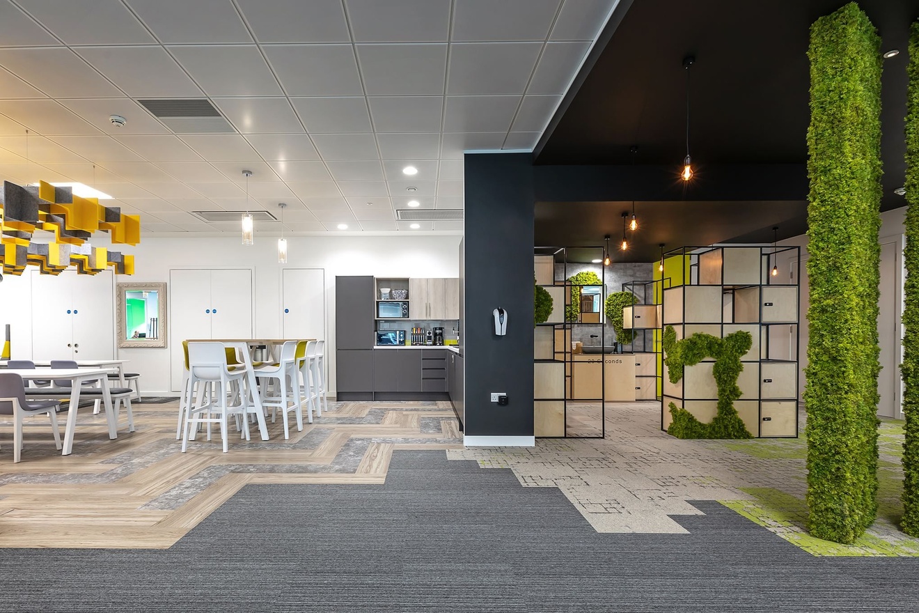 An office kitchen, hand wash room and seating area.